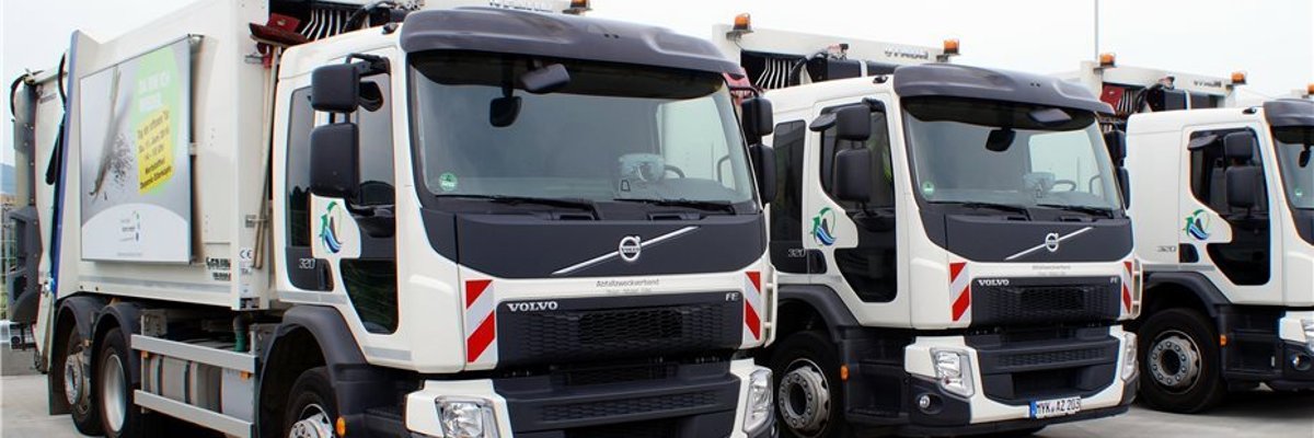 Drei schräg nebeneinander parkende Abfallsammelfahrzeuge des Abfallzweckverbandes Rhein-Mosel-Eifel.