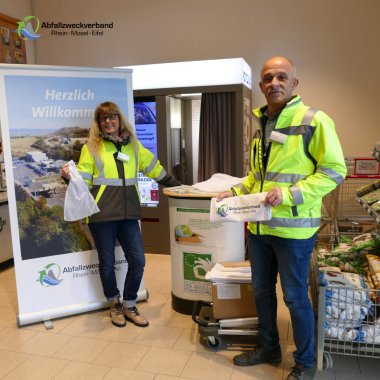 Mitarbeiter der Umweltberatung stehen an einem Infostand im REWE Markt in Plaidt