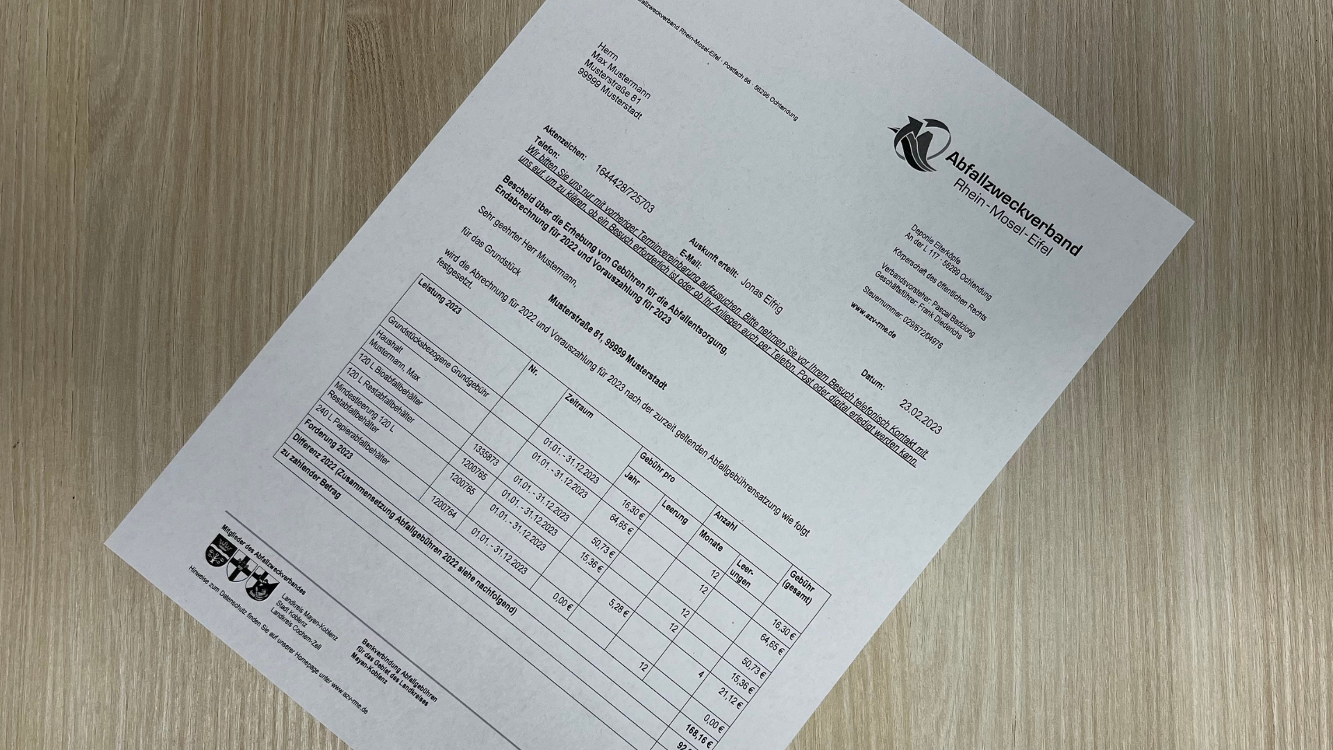 Ein Musterbescheid für die Abfallgebühren liegt quer auf einem Tisch.