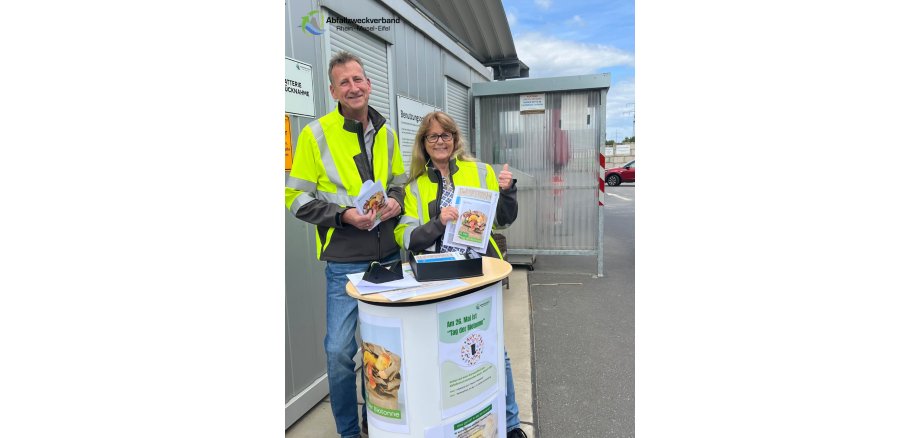 Mitarbeiter der Umweltberatung stehen an einem infostand auf dem Wertstoffhof
